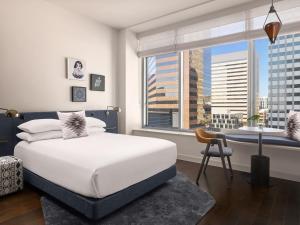 a bedroom with a white bed and a large window at Kimpton Alma San Diego, an IHG Hotel in San Diego