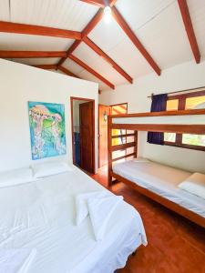 two beds in a room with two bunk beds at Surfing Turtle Lodge in Poneloya