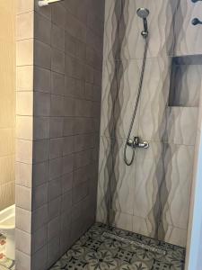 a bathroom with a shower with a tile floor at Green Plaza-SeaView in Aktau