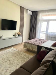 a living room with a couch and a television at Green Plaza-SeaView in Aktau
