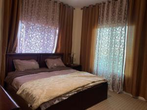 a bedroom with a bed and a window with curtains at Petra Rest Home in Wadi Musa