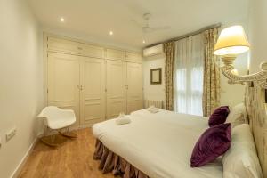 a bedroom with a large white bed with purple pillows at Wide with beautiful kitchen 2Bd 3Bth -Arenal in Seville
