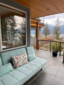 eine blaue Couch auf einer Veranda mit Aussicht in der Unterkunft The Sentinel in Kaslo