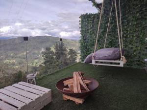 een schommel met een bed en een tafel op het gras bij Sukha Resort in La Calera