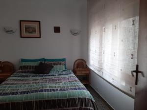 1 dormitorio con cama y ventana en Casa de montaña en plena naturaleza, jacuzzi, sauna y piscina, en Bisbal del Penedès