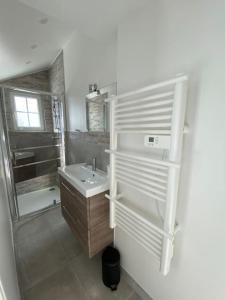 a white bathroom with a sink and a shower at Bel appartement avec jardin au coeur d'Etretat in Étretat