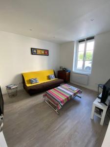 a living room with a bed and a window at Bel appartement avec jardin au coeur d'Etretat in Étretat