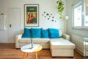 リスボンにあるBright Apartment in Lisbonのリビングルーム(白いソファ、青い枕付)