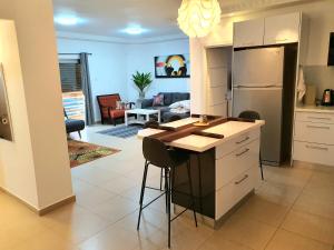 a kitchen with a kitchen island with a refrigerator at VILLA SITVANiT- וילה סיתוונית by barak royal suites in Eilat