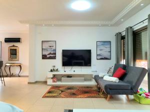 a living room with a couch and a tv at VILLA SITVANiT- וילה סיתוונית by barak royal suites in Eilat