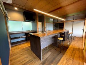 uma cozinha com um lavatório e um balcão com bancos em I,K,I HOUSE TSURUKIFURE - Vacation STAY 14773v em Iki