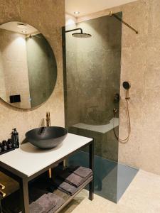 uma casa de banho com um lavatório e uma cabina de duche em vidro. em Guesthouse Andor em Balen