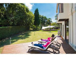 米子的住宿－Glamp House DAISEN Garden - Vacation STAY 97255v，两人躺在露台上的躺椅上