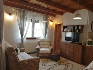 sala de estar con 2 sillas y TV en Holiday Home Slavica, en Kupres