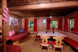 ein Wohnzimmer mit einem Tisch, Stühlen und einem Sofa in der Unterkunft Ferienchalet Kreuzlauhof MAY-101 in Schwendau