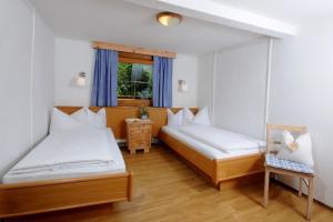 1 dormitorio con 2 camas y ventana en Ferienchalet Kreuzlauhof MAY-101, en Schwendau