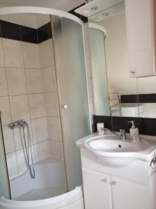 uma casa de banho com um chuveiro, um lavatório e um espelho. em Holiday Home Slavica em Kupres