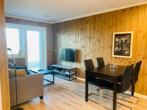 a living room with a dining room table and a television at Perfect Christmas atmosphere! Beautiful Apartment at Skagahøgdi with Panoramic View in Gol