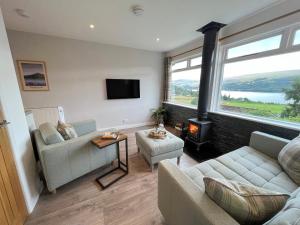 a living room with a couch and a fire place at Ciaran Cottage in Stron-fearnan