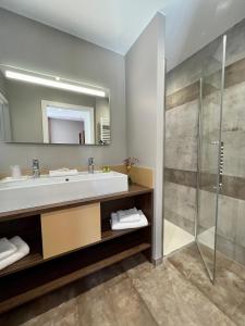 La salle de bains est pourvue d'un lavabo et d'une douche. dans l'établissement Hôtel les Bergeronnettes, à Champagneux