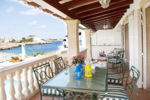 una mesa en un balcón con vistas al océano en Villa Marsal, en Portocolom