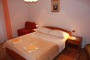 a bedroom with a bed and a red chair at Apartments Boris in Zaton