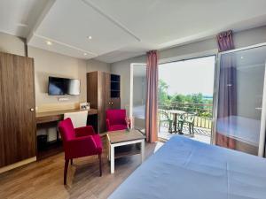 une chambre d'hôtel avec un lit, une table et des chaises dans l'établissement Hôtel les Bergeronnettes, à Champagneux
