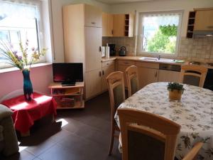 a kitchen with a table and a kitchen with a table and chairs at Quiet apartment in Neukirch with private terrace in Furtwangen