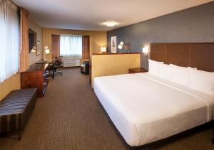 波特兰Silver Cloud Hotel - Portland的配有一张大床和一张书桌的酒店房间