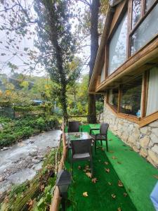 a patio with a table and chairs next to a river at Taş_suit in Kartepe