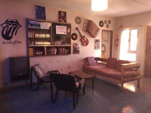 a living room with a couch and chairs in it at Hostel "La Casita Naranja" in El Bolsón