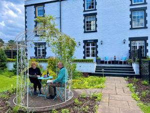 Ein Mann und eine Frau sitzen an einem Tisch in einer Metallkonstruktion in der Unterkunft Eagle House - award winning luxury B&B and Apartment in Eccleshall