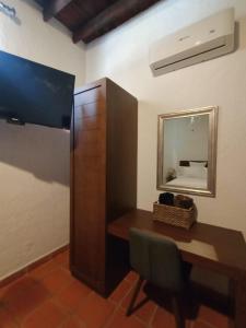 a room with a desk and a tv and a mirror at Acueducto Hotel Boutique in Parras de la Fuente