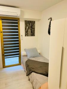 a small bedroom with a bed and a window at 3 pièces terrasse, jardin in Cannes