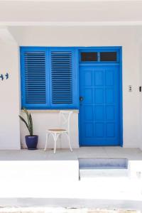 eine blaue Tür und ein Hocker vor einem Gebäude in der Unterkunft Blue Levant Guest House in Famagusta