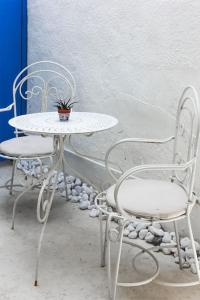 una mesa blanca y sillas con una maceta. en Blue Levant Guest House, en Famagusta
