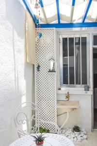 eine Terrasse mit einem Tisch, einem Stuhl und einem Fenster in der Unterkunft Blue Levant Guest House in Famagusta