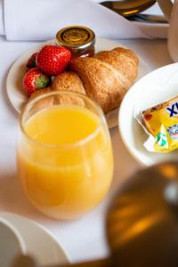 a glass of orange juice next to a plate of fruit at Milford Hall Hotel & Spa in Salisbury