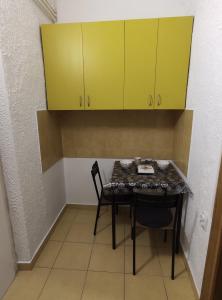 a table and a chair in a room with yellow cabinets at Beogradski sajam san - Belgrade Fair sleep in Belgrade