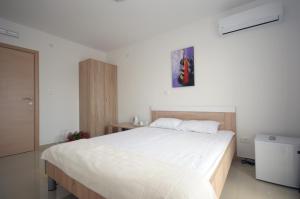 ein Schlafzimmer mit einem großen weißen Bett in einem Zimmer in der Unterkunft Apartments Vila Anastasia in Budva