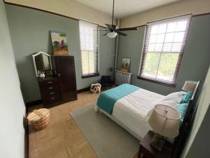 een slaapkamer met een bed, een tv en ramen bij St Joseph Farmstead in North Little Rock