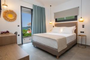 um quarto com uma cama e uma grande janela em SEASCAPE VILLAS VASSILIKI - Beachfront villas em Vasiliki