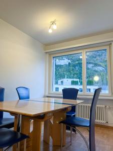 una sala da pranzo con tavolo, sedie e finestra di Schöne grosse Attika-Wohnung im Zentrum von Vaduz inkl. Parkplatz a Vaduz