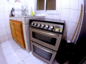 Il comprend une cuisine équipée d'une cuisinière et d'un évier. dans l'établissement TrierHouse, à Douala