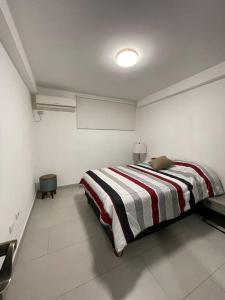 1 dormitorio con 1 cama con manta a rayas en Hermosa suite en el centro Histórico de Guayaquil, en Guayaquil