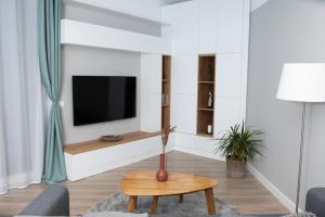 a living room with a tv and a table at Anise Apartment in Bucharest