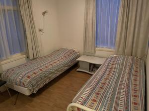 two beds sitting in a room with a window at Boerenkiel Vakantiehuisjes in De Kiel