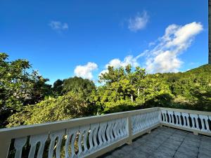 Una barandilla blanca en un balcón con árboles al fondo. en A Luxurious 4-Bedroom Private Villa with Games Room, Theatre & Modern Art, en Montego Bay