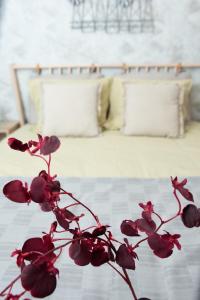 a plant with red flowers in front of a bed at Anise Apartment in Bucharest
