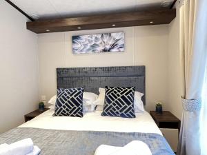 sypialnia z łóżkiem z niebiesko-białymi poduszkami w obiekcie Stewarts Resort Lodge 32 w mieście St Andrews